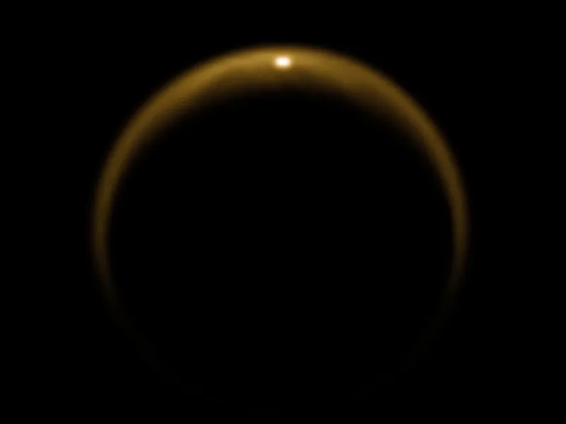 An image of Titan captured by the Cassini spacecraft on July 2009. The bright spot at the top of Titan’s disc is sunlight reflecting off the surface of a hydrocarbon lake. Dragonfly will explore these pools of liquid to search for conditions suitable for the development of life. Credit: NASA/JPL/University of Arizona/DLR