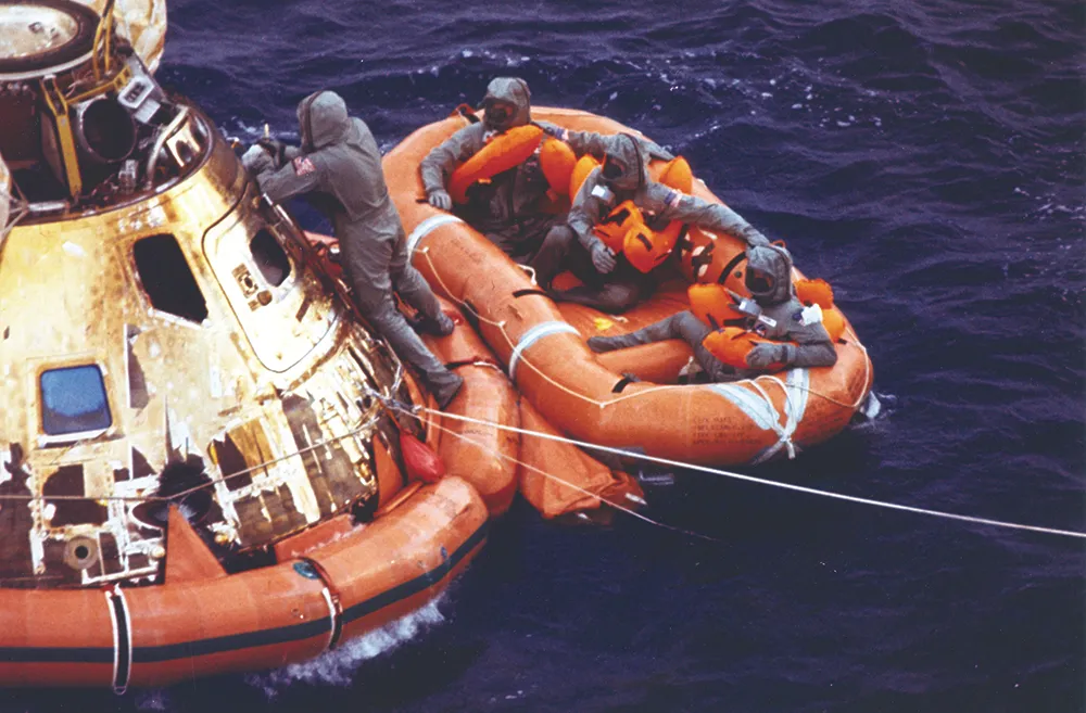 24 July 1969. Columbia made splashdown at 4.50pm GMT. Half an hour later, the crew, dressed in their isolation garments, wait to be picked up by helicopter while a Navy diver secures the open hatch. Credit: NASA