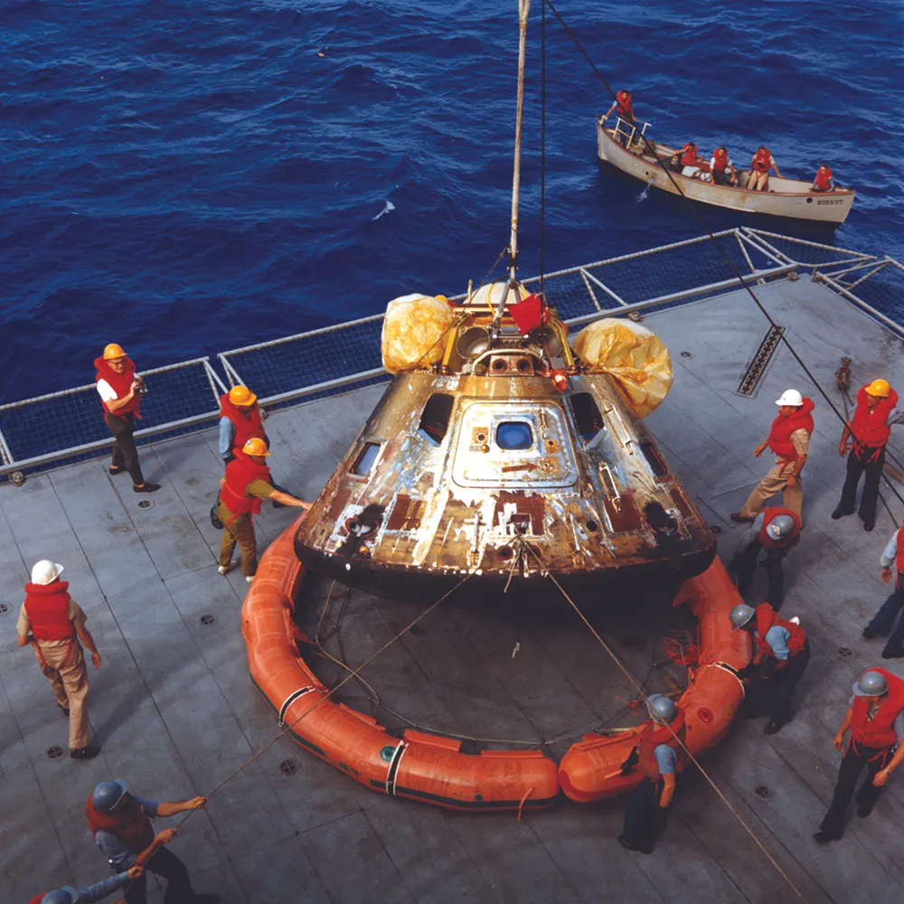 24 July 1969. The command module is lowered onto the deck of the USS Hornet to be prepared for transport back to the Lunar Receiving Laboratory in Houston. At the top are the three air sacks that inflated to right the module when it came to rest upside-down after splashdown. Credit: NASA