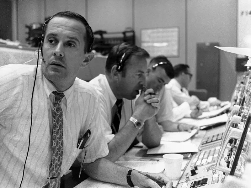 Charlie Duke (left), Jim Lovell (middle) and Fred Haise (right) pictured in Mission Control. Credit: NASA