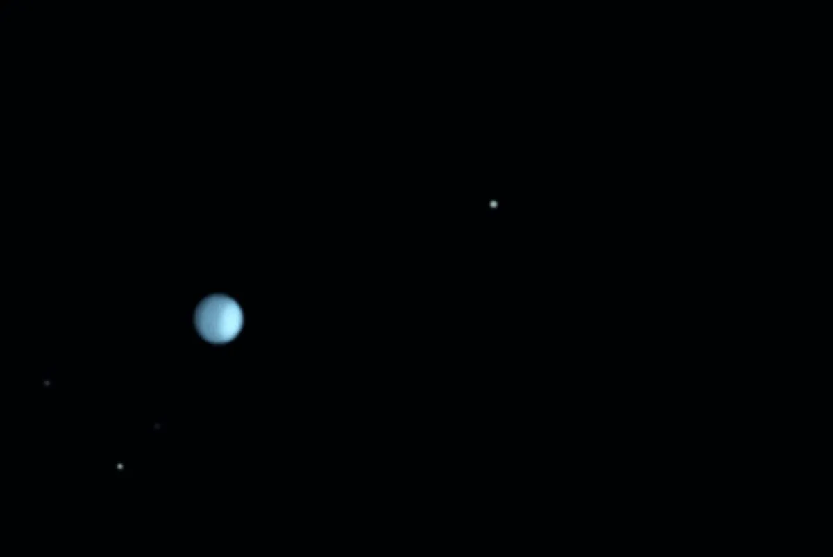 Uranus on 18 December 2017, showing surface details in infrared. The lighter polar region is tipped to the right. The moons were exposed separately from the planet and in visible light, not IR. Credit: Martin Lewis