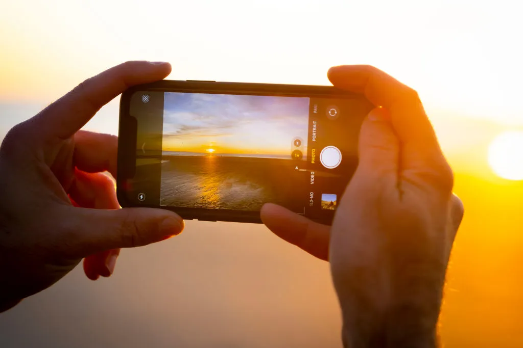 Photographing a sunset with an Apple iPhone. Photo by Matthew Horwood/Getty Images