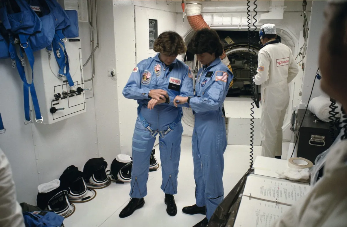 Sullivan (left) pictured with fellow NASA astronaut Sally Ride (right). The two astronauts are synching their watches before the launch of Shuttle mission STS-41G on 5 October 1984. The mission was the first flight to carry two women into space. Credit: NASA