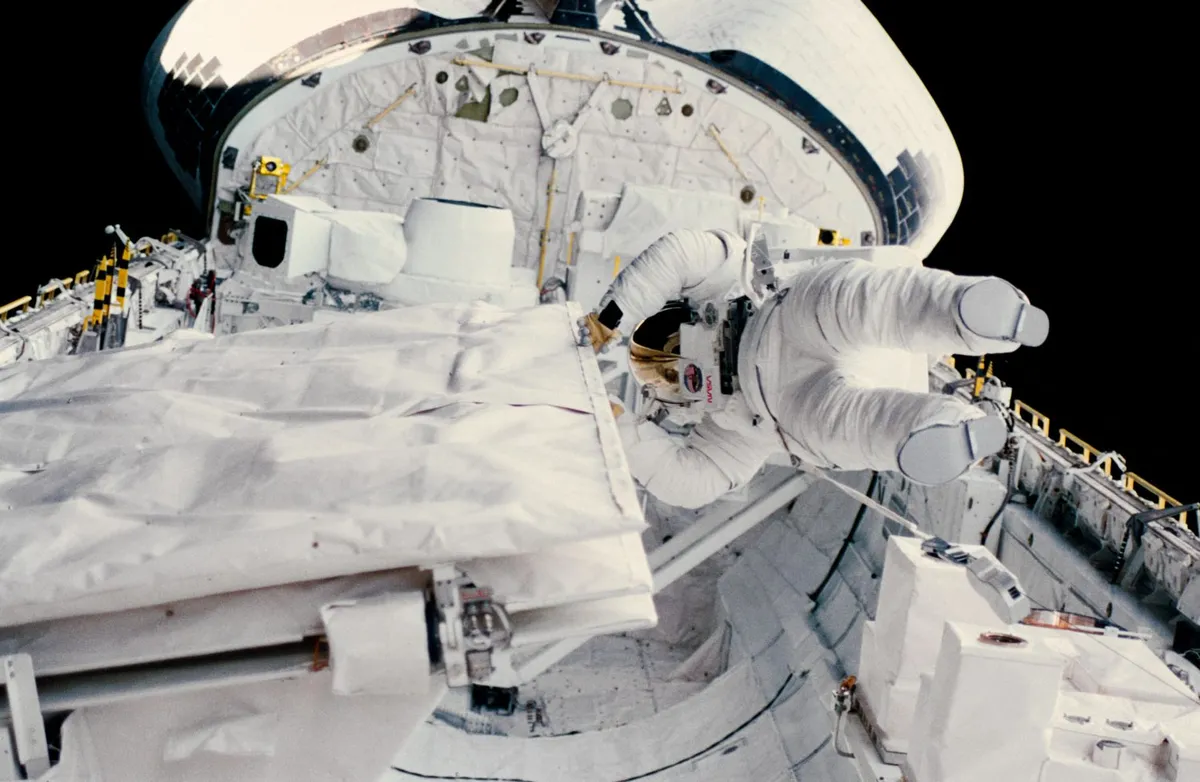 Kathy Sullivan becomes the first US woman to spacewalk, 11 October 1984. Here Sullivan is checking the latch of the SIR-B antenna in the Space Shuttle Challenger's open cargo. Credit: NASA