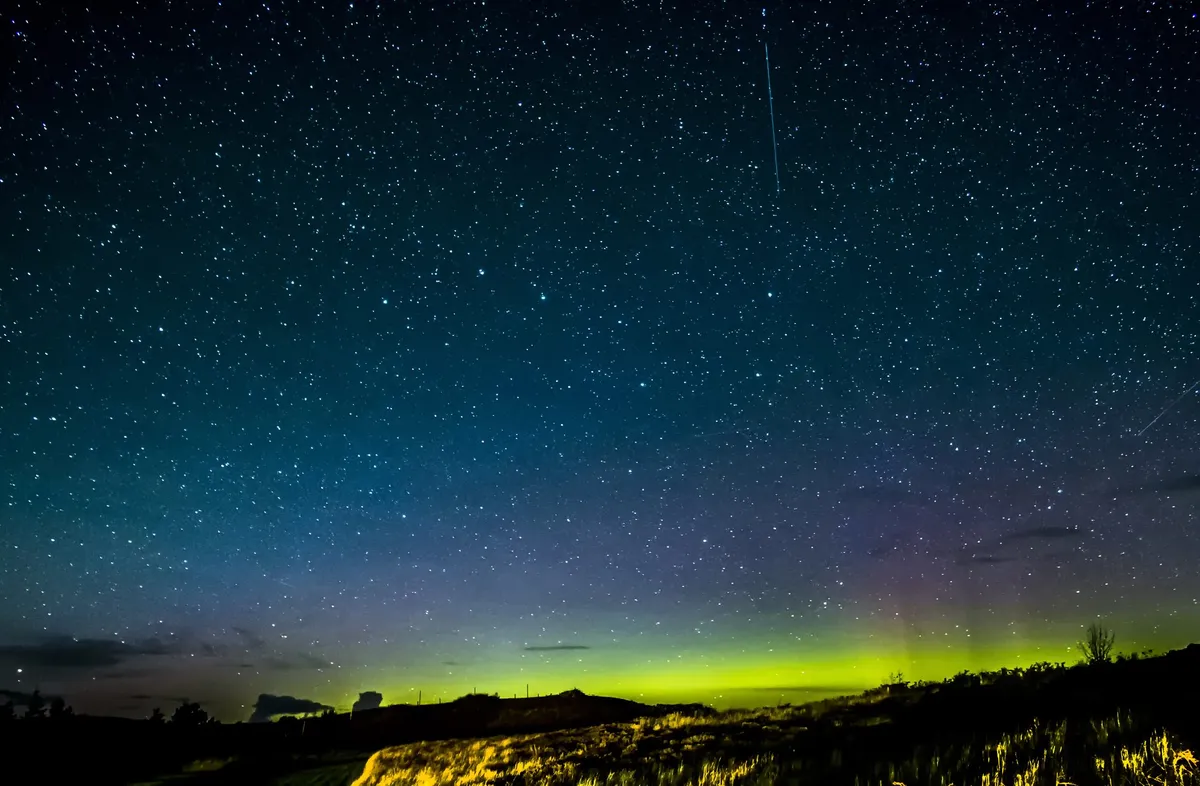 A starry sky and the Northern Lights appear over the Isle of Skye. Credit: rosn123 / Getty Images