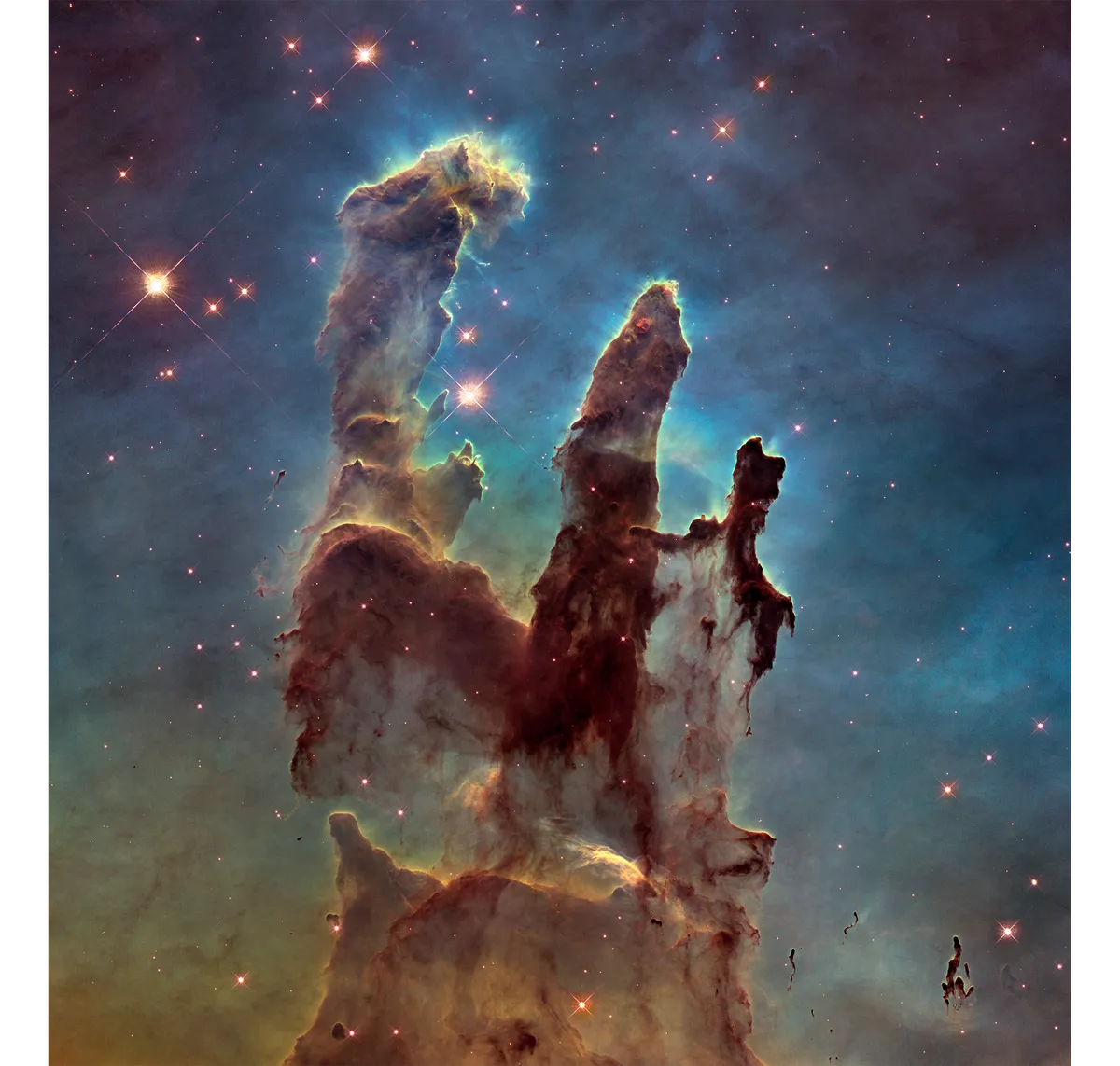 One of Hubble’s most iconic images, the Eagle Nebula’s Pillars of Creation unveils the multicoloured glow of gas clouds interspersed with wispy tendrils of dark cosmic dust. Originally captured in April 1995 (see inset), the new image was released almost 20 years later. It captures more detail on the rust-coloured elephant trunks of the nebula’s legendary pillars. The dust and gas in these is seared by the radiation from nearby young stars. The nebula is 7,000 lightyears away. Credit: NASA, ESA/Hubble and the Hubble Heritage Team