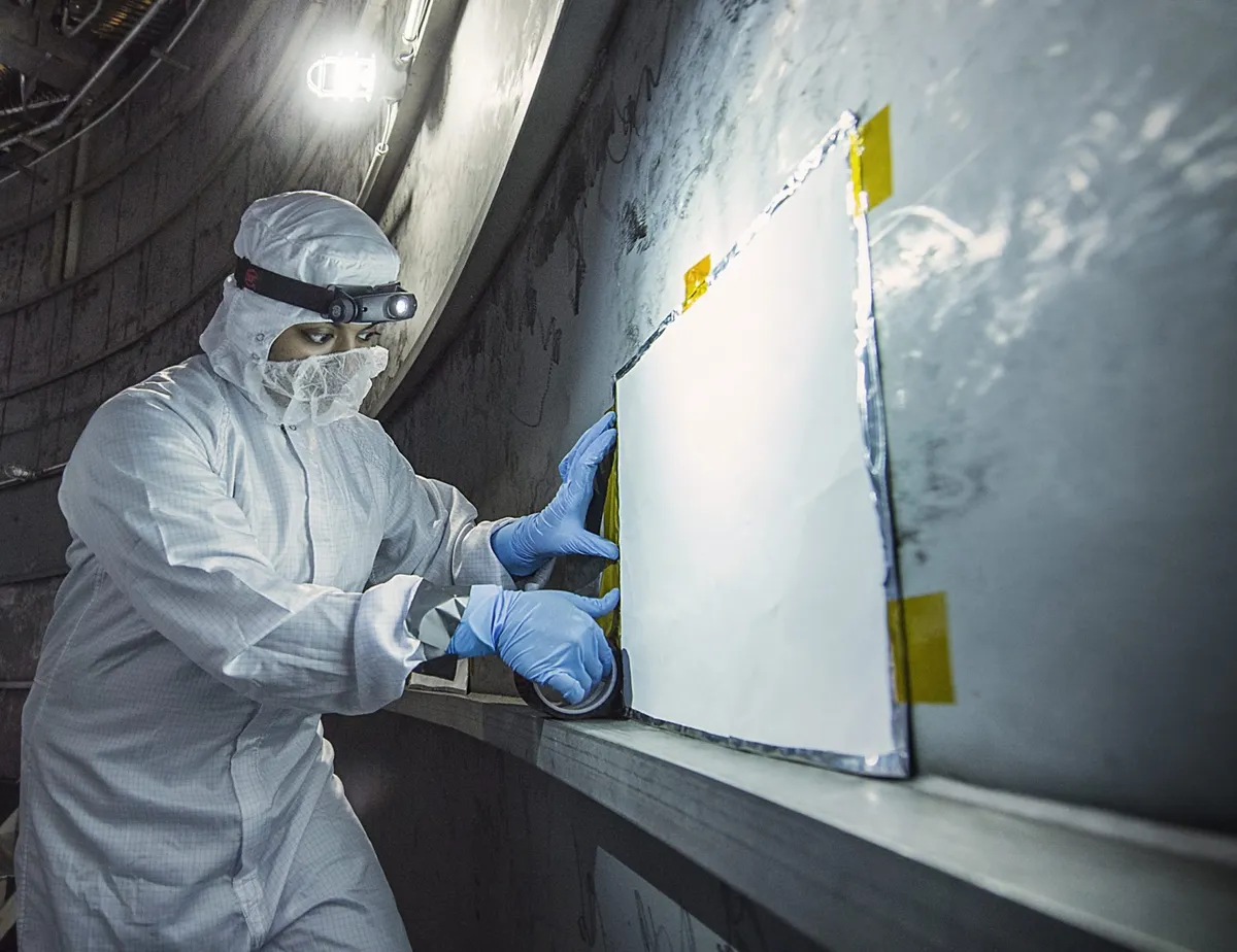 Coatings engineer Nithin Abraham pictured in an area beneath Chamber A at NASA's Johnson Space Center where scientists test critical contamination control technology to keep James Webb Space Telescope clean during cryogenic testing. Credit: NASA/Chris Gunn
