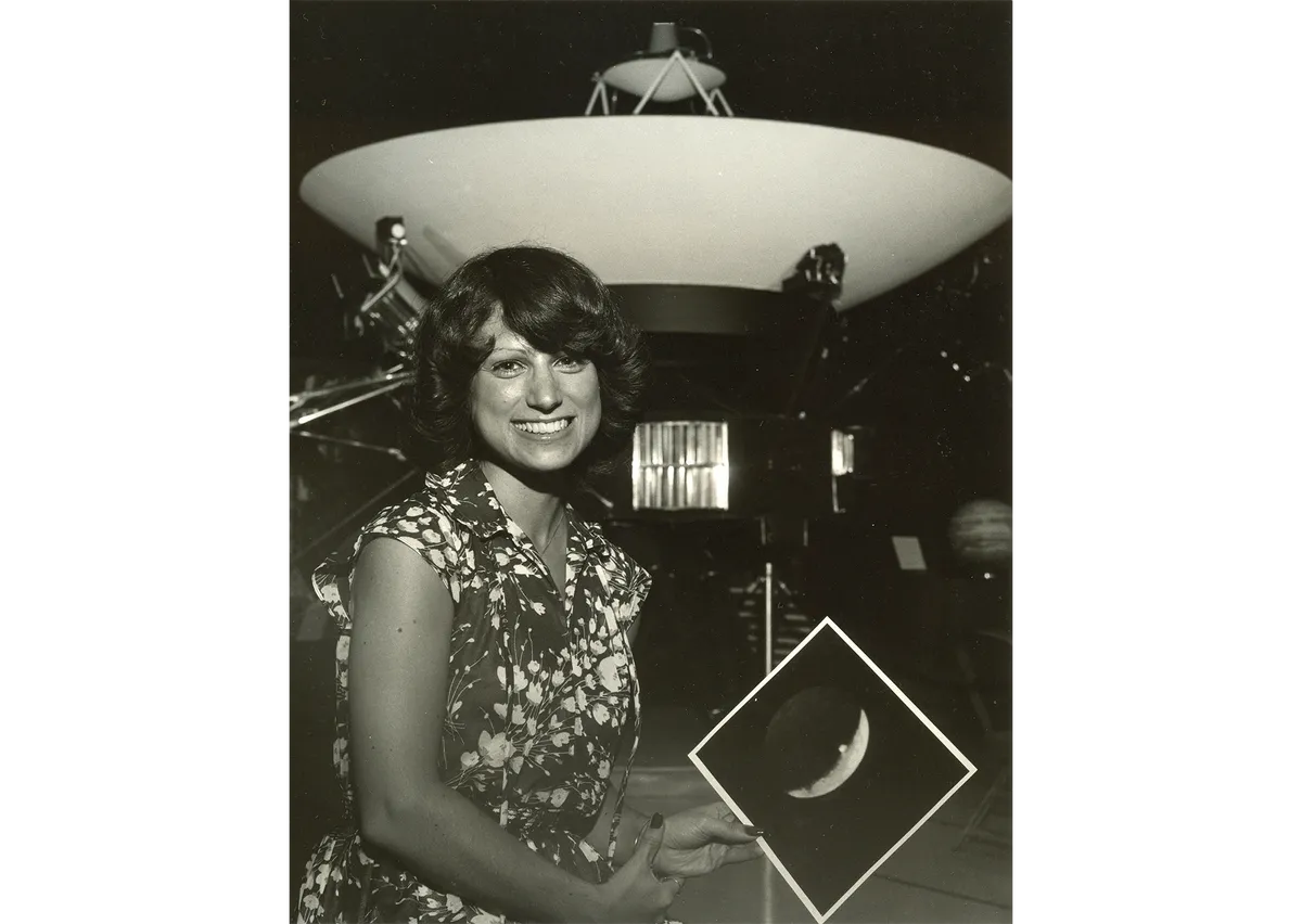 Linda Morabito pictured after her discovery of Io volcanism, in front of a model of the Voyager spacecraft at NASA's Jet Propulsion Laboratory. Morabito is holding a print of the image that enabled her to make the discovery. Credit: NASA