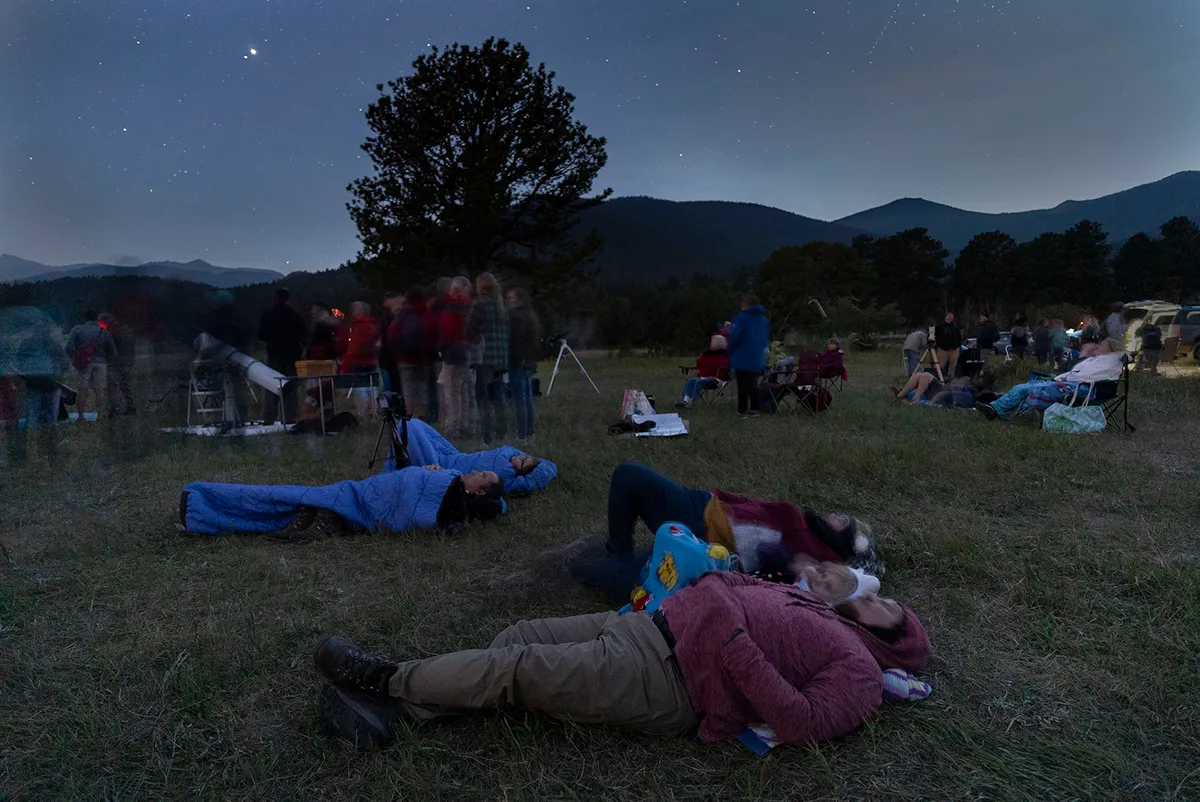 Lying or reclining is a great way to observe meteor showers without getting cramp in your neck. Here, meteor watchers await the Perseid peak of 12 August 2018 at the Rocky Mountain National Park in the US. Credit: STAN HONDA / AFP via Getty Images.