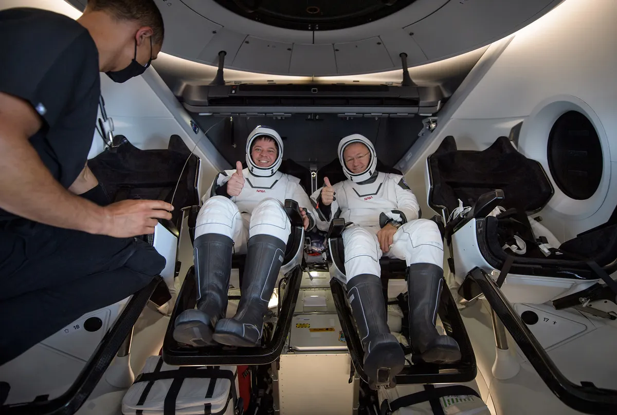 NASA astronauts Robert Behnken, left, and Douglas Hurley, inside the SpaceX Crew Dragon Endeavour spacecraft onboard the SpaceX GO Navigator recovery ship shortly after their splashdown in the Gulf of Mexico, 2 August 2020. Credit: NASA/Bill Ingalls.