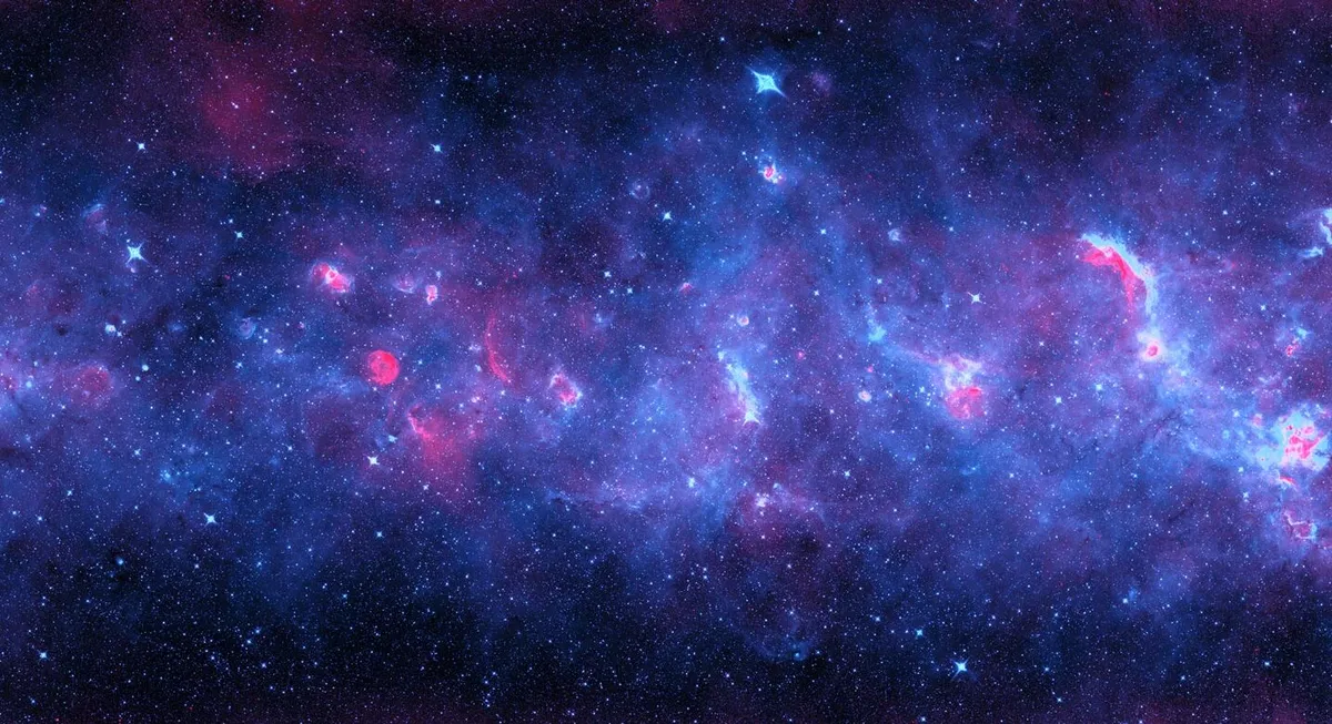 A radio and infrared image of a section of the Milky Way. Radiation from newborn stars heats cosmic dust that glows in infrared (in violet). Ultraviolet light from these stars gives off radio waves in red. Credit: NRAO/AUI/NSF