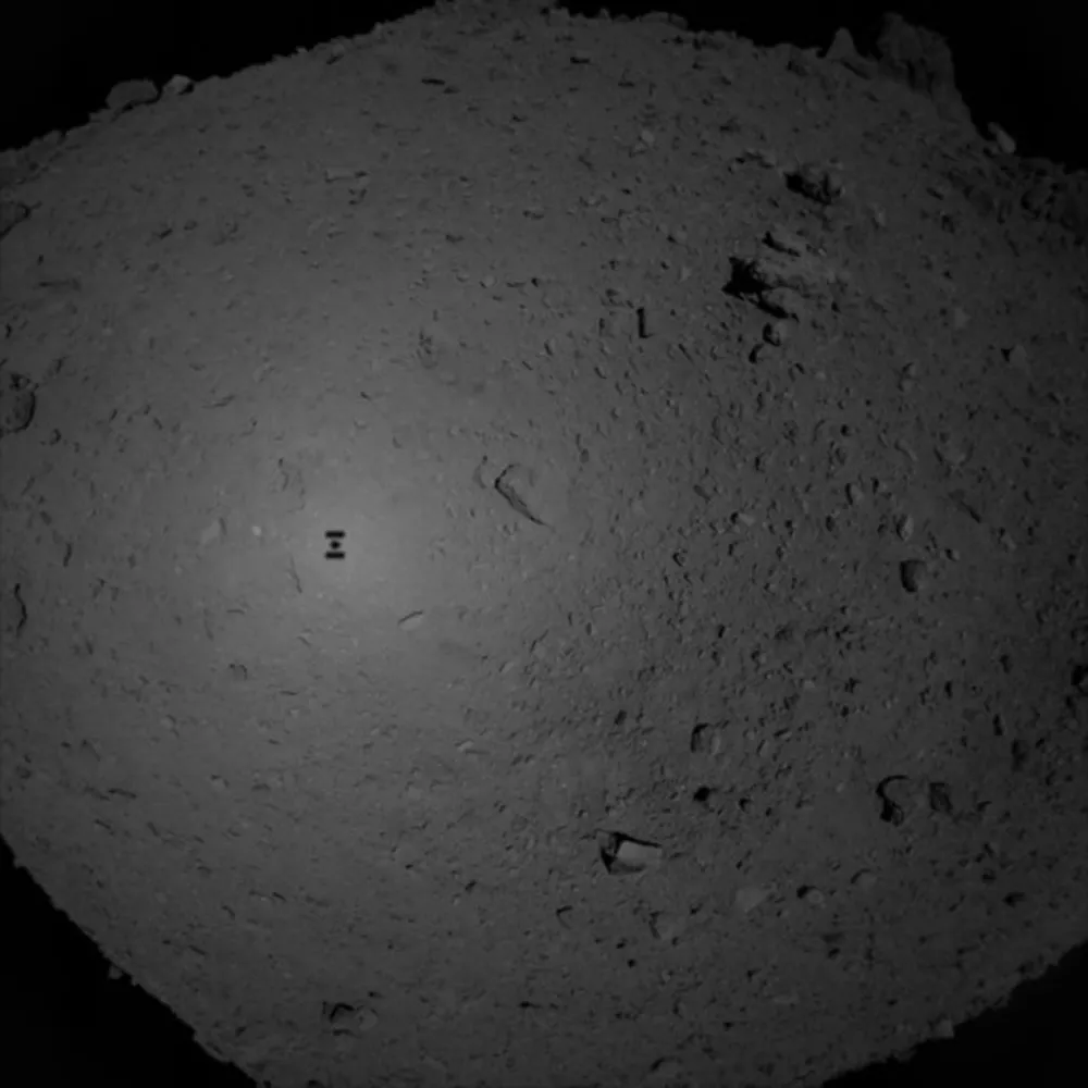 The shadow of Hayabusa 2 appears on asteroid Ryugu during TD1-L08E1, the mission's first touchdown operation, in February 2019. Credit: JAXA