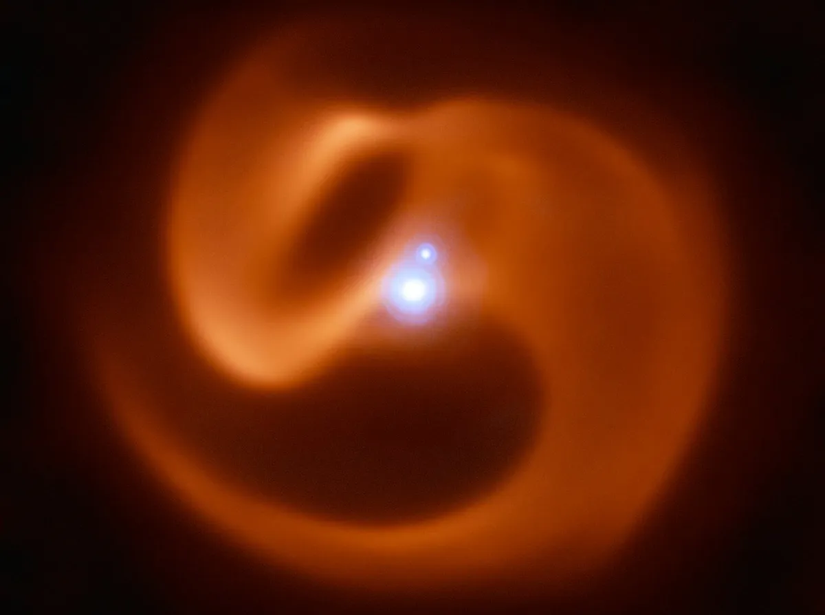 This image shows a binary star system known as Apep, where stellar winds have created a swirling dust cloud around the two stars. Credit: ESO/Callingham et al.