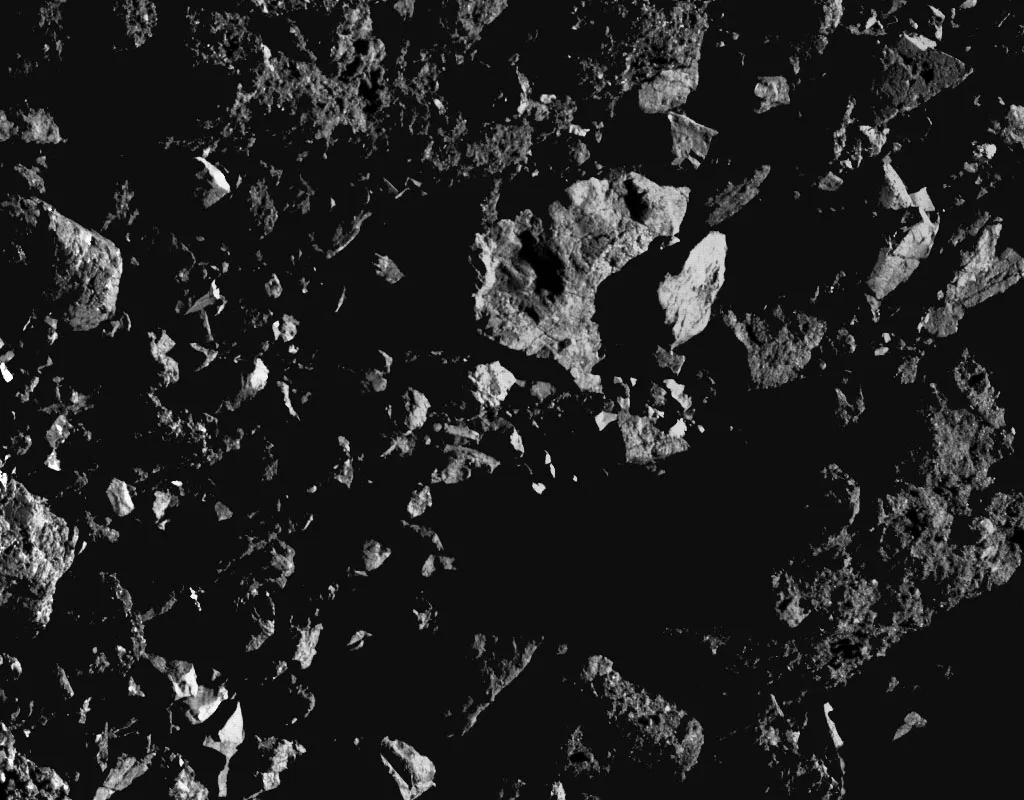 A region in asteroid Bennu's southern hemisphere showing large boulders and an accumulation of rocks. This image was captured on 5 August 2019 when OSIRIS-REx was just 0.6km from the surface. The rock casting a shadow on the bright central boulder is 4ft long. Credit: NASA/Goddard/University of Arizona