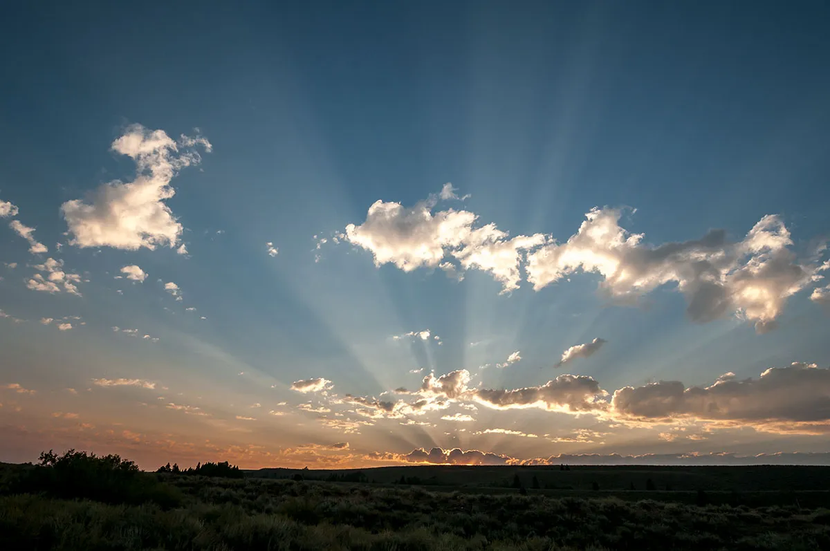 Sunlight filters through clouds creating crepuscular rays, also known as 'God rays', in this image captured at Grand Tetons National Park in the US in 2017. Similar effects could be occurring at galaxy IC 5063 where light is partially blocked by the dusty disc surrounding the supermassive black hole at its centre. Credit: Z. Levay The photographer was facing east—away from the iconic Grand Teton Mountains—when he snapped this image in 2017. The light rays are formed by sunlight piercing the clouds. The darker regions represent the clouds casting shadows where sunlight could not pass through. This interplay of light and shadow is similar to the bright rays and dark shadows stretching across the nearby active galaxy IC 5063. In that case, a monster black hole in the galaxy’s core is producing a gusher of light from superheated infalling gas. Most of the light is penetrating the dust ring encircling the black hole, creating the bright rays. However, some light hits dense patches in the ring, casting the ring’s shadow into space.