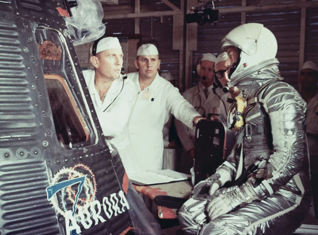 Scott Carpenter at Cape Canaveral, conversing with NASA technicians as he prepares to enter his Aurora 7 Mercury spacecraft. Carpenter would successfully complete a 3-orbit flight of the Earth. Credit: Bettmann / Getty Images