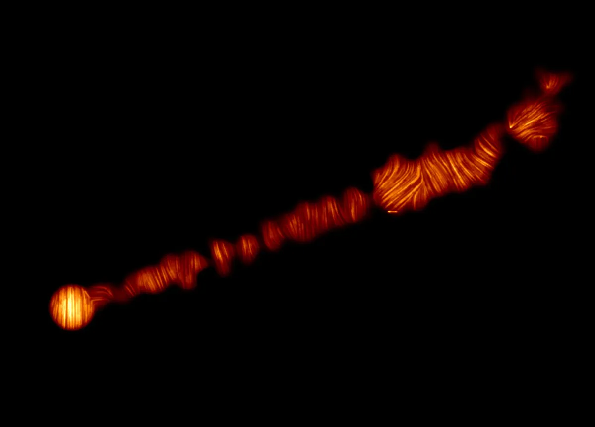 A 6,000 lightyear-long jet in galaxy M87, captured with the Atacama Large Millimeter/submillimeter Array (ALMA) Lines show the orientation of polarisation, related to the magnetic field in the region. Credit: ALMA (ESO/NAOJ/NRAO), Goddi et al.
