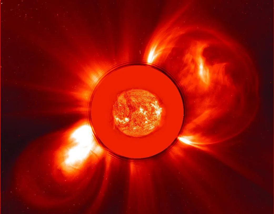 An image of the Sun captured by the SOHO telescope, showing two coronal mass ejections. Another SOHO image of the Sun taken on the same day has been superimposed over the dark disk in the main image that blocks the sun so the telescope can observe surface structures in visible light. Credit: ESA/NASA/SOHO