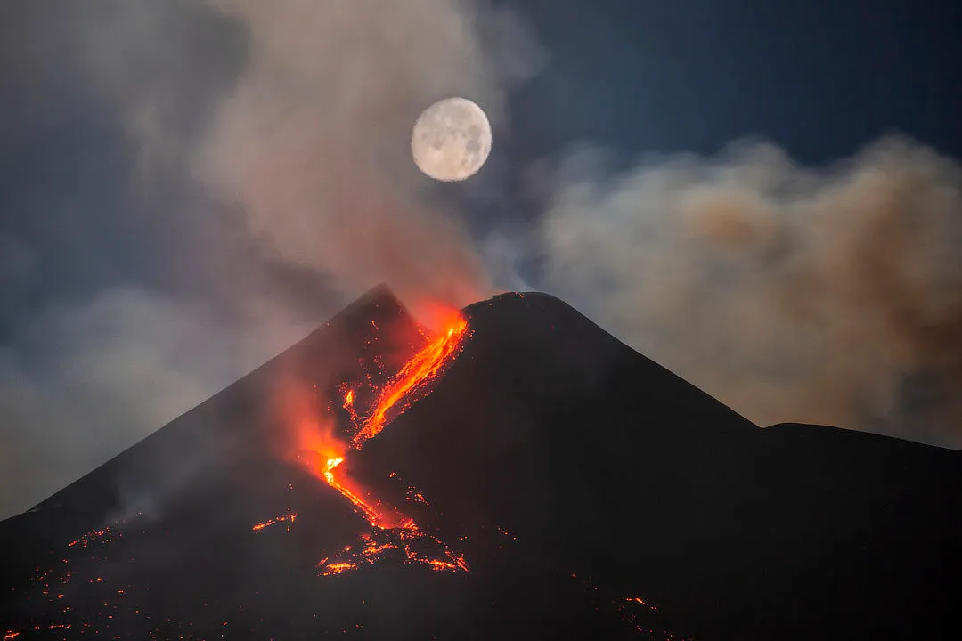Moon Over Mount Etna South-East Crater, by Dario Giannobile (Italy). Runner up, Skyscapes. Milo, Sicily, Italy, 25 February 2021. Equipment: Canon EOS 6D camera, Sigma 150–600 mm lens at 347 mm f/5.6.