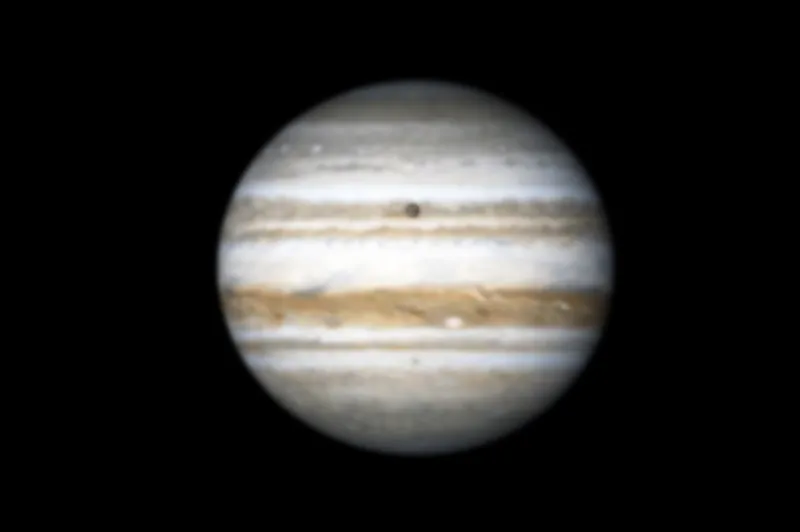 An image showing Jupiter with its moon Callisto passing in front as a black dot