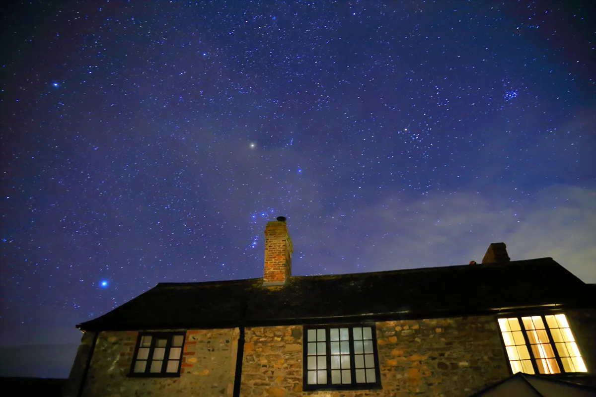 The constellation Orion above a house at night. Credit: Savoilic / Getty Images
