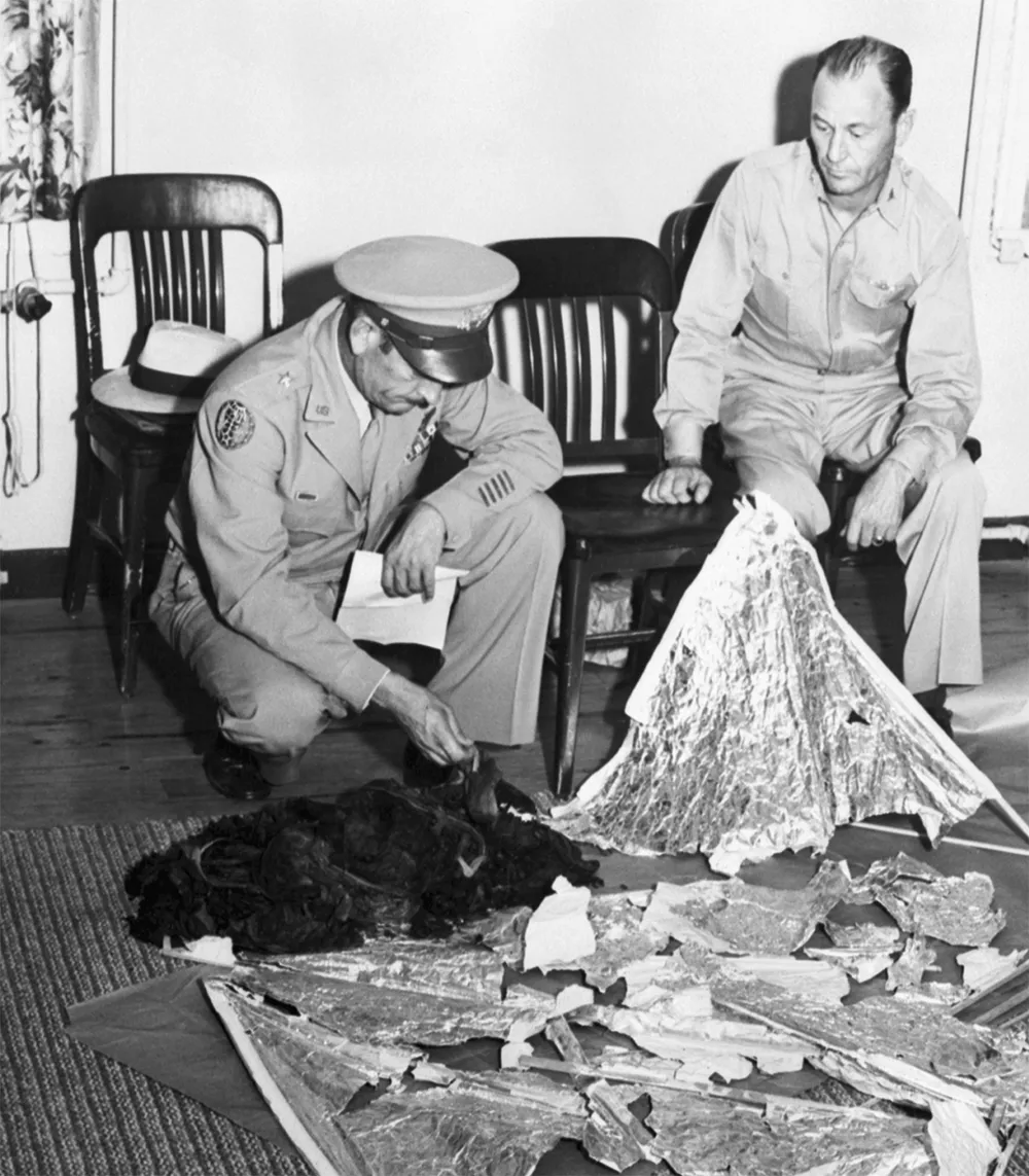 At Fort Worth Army Air Field on 8 July 1947, Brigadier General Roger M Ramey (left) and Colonel Thomas J Dubose, identify metallic fragments found at Roswell as pieces of a weather balloon. Credit: Bettmann / Getty Images