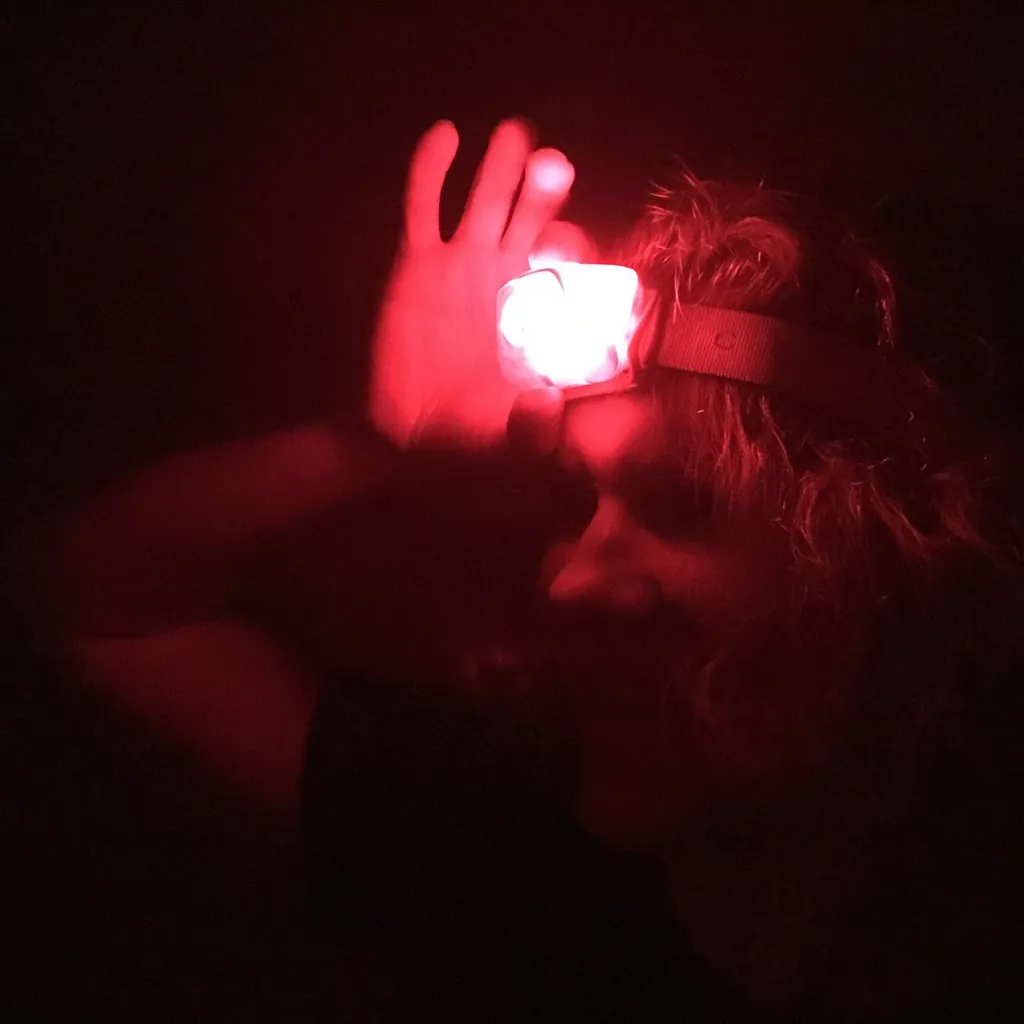 Woman adjusts red light head torch