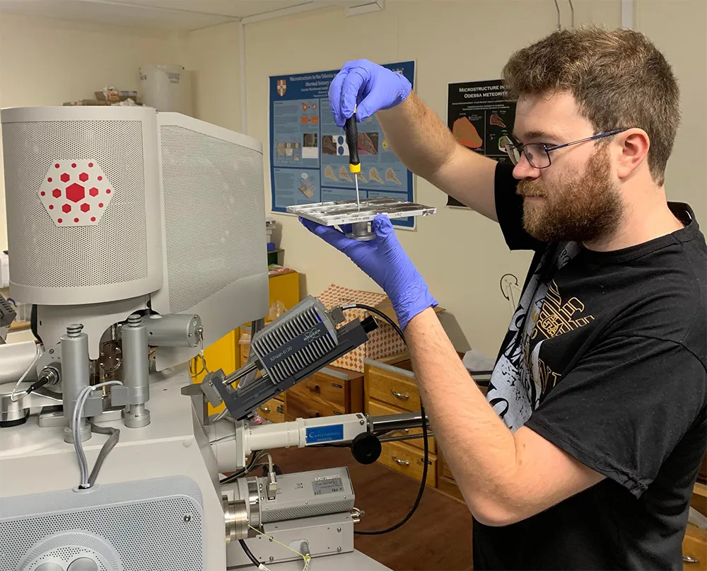 Craig Walton, from the University of Cambridge’s Department of Earth Sciences, prepares meteorite samples for analysis on a scanning electron microscope. Credit: University of Cambridge Department of Earth Sciences