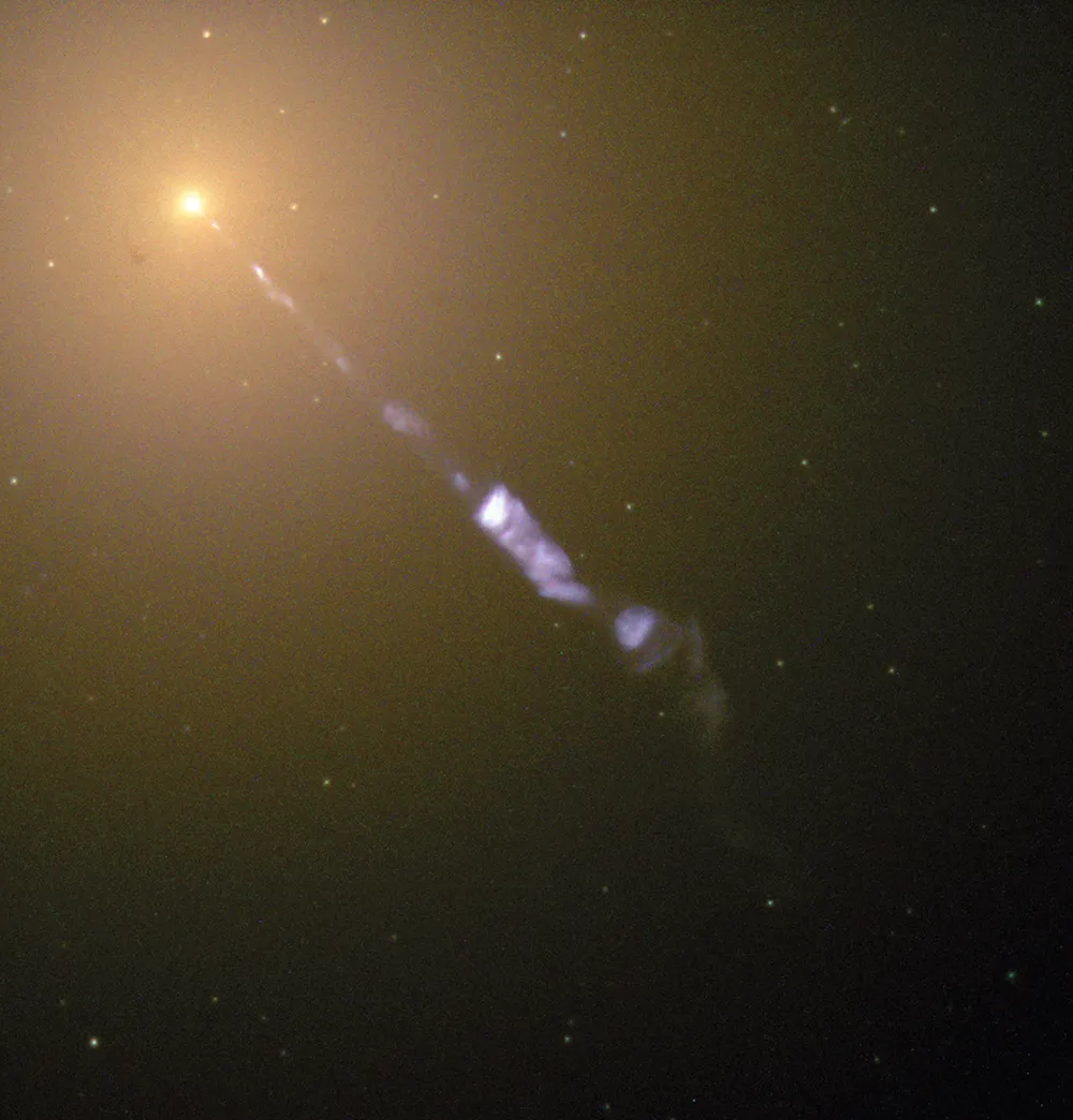 February 1998 Streaming from the centre of the galaxy M87 like the beam of a lighthouse is a black-hole-powered jet of electrons and other sub-atomic particles travelling at nearly the speed of light. The blue of the jet contrasts with the yellow glow from the combined light of billions of unseen stars that make up the galaxy, which lies 50 million lightyears away.