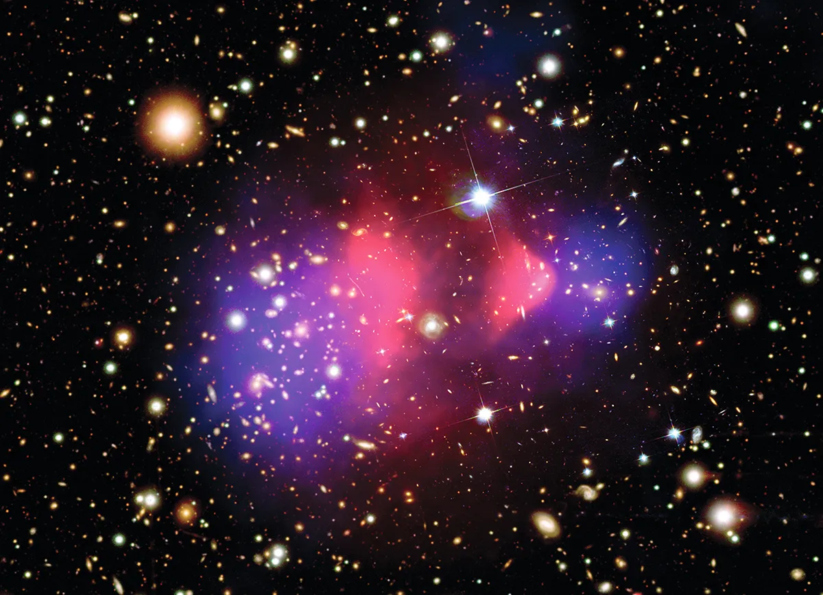 14-19 January 2009 Data from Hubble and the Chandra X-ray observatory combine in this image of galaxies colliding in the Bullet Cluster. It shows that most of the mass of galaxies is separate from the cluster’s hot gas, which is shown in pink. From this astronomers infer the presence of dark matter in the areas coloured blue.
