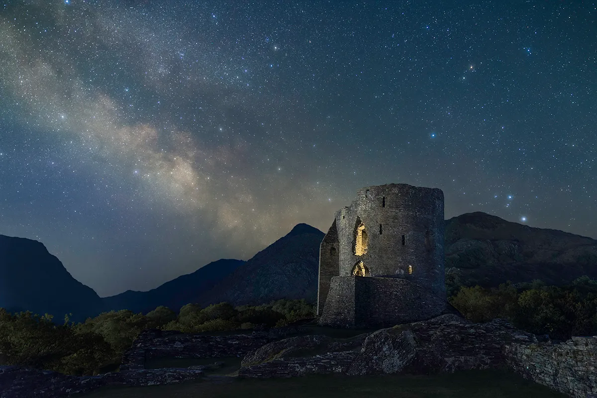 Dolbadarn Castle, Home of Welsh Princes, by Robert Price, Llanberis, Gwynedd, Wales, United Kingdom. Category: People & Space Equipment: Canon EOS 6D Mark II camera, Sky-Watcher Star Adventurer Mini mount, 24 mm f/2.8, ISO 800; Sky: 25 x 120-second exposures; Foreground: 10 x 45-second exposures