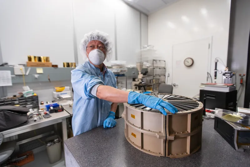 XRISM team member Yang Soong of the University of Maryland, College Park, with the completed mirror elements for an X-ray Mirror Assembly developed for the JAXA/NASA XRISM mission. Credit: Taylor Mickal/NASA