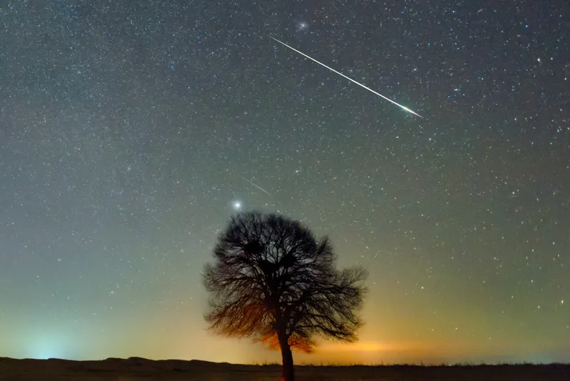 A Geminid meteor, seen originating from the radiant of Gemini, passing south of Orion. Credit: Wenbin / Getty Images