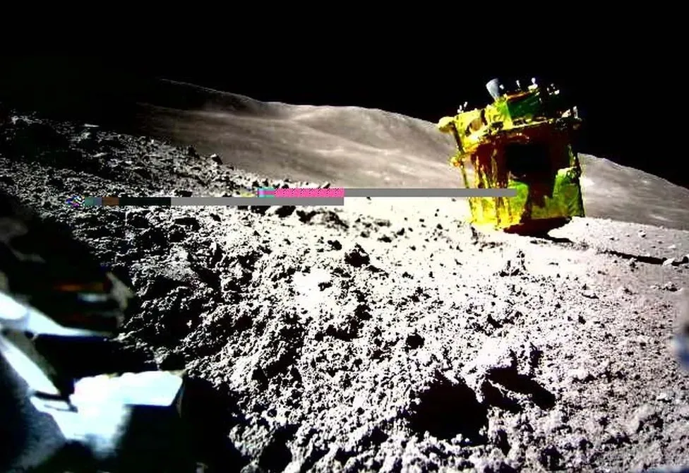 The SLIM lander on its nose on the lunar surface. It's thrusters and feet are pointing in the air.