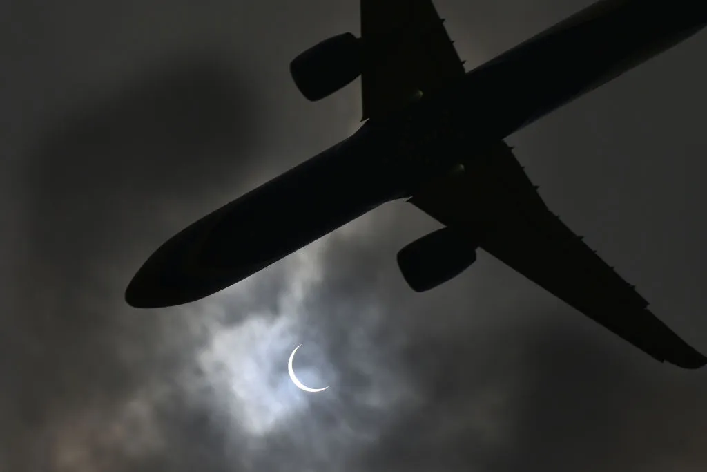 Plane passing beneath a partial solar eclipse, 21 June 2020 in New Delhi, India. Photo By Vipin Kumar/Hindustan Times via Getty Images