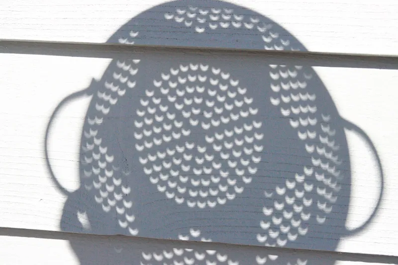 The 14 October 2023 annular solar eclipse captured through a kitchen colander by Donald Samuels from Colorado, USA.