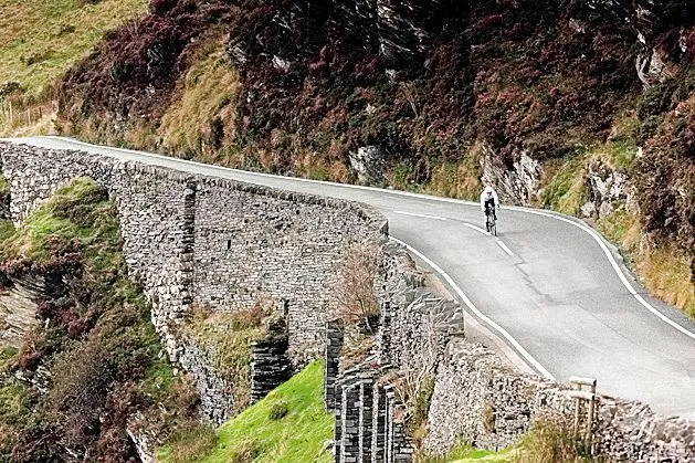 Cyclist riding fast on road in Bala North Wales