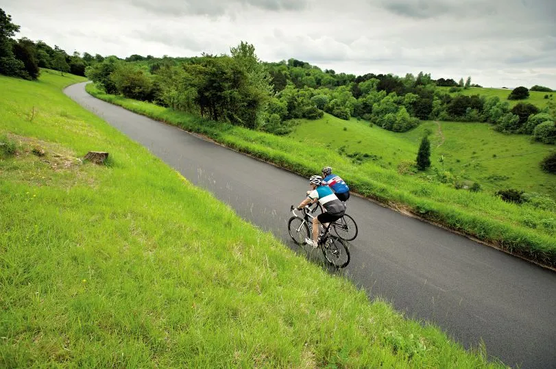 Two cyclist ride up the iconic Box Hill climb near Dorking in Surrey
