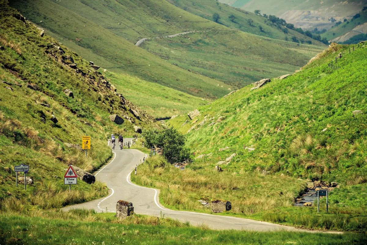 Two cyclists riding into the distance in the Elan Valley Wales