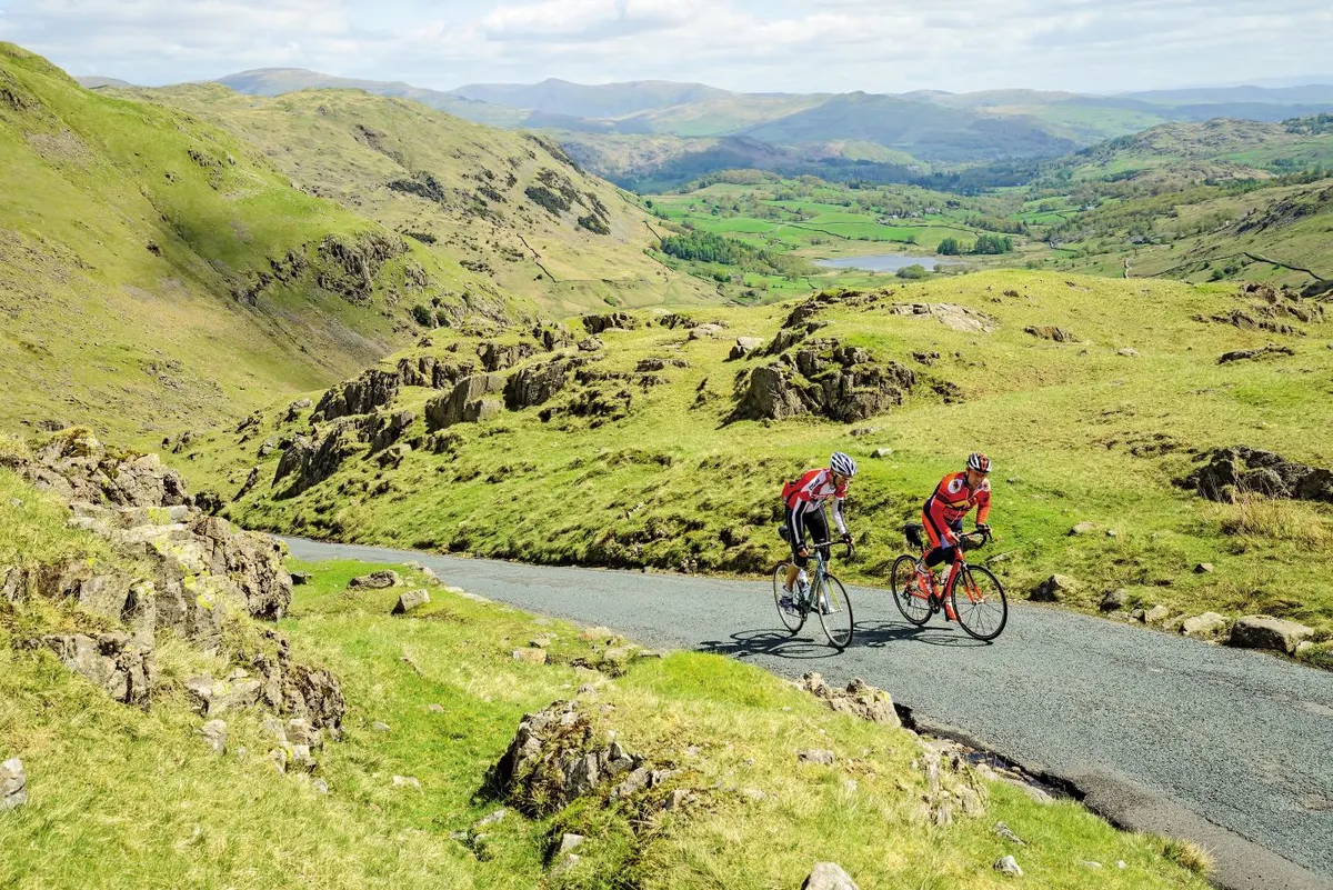 Two cyclists climbing Wrynose Pass in the Lake District