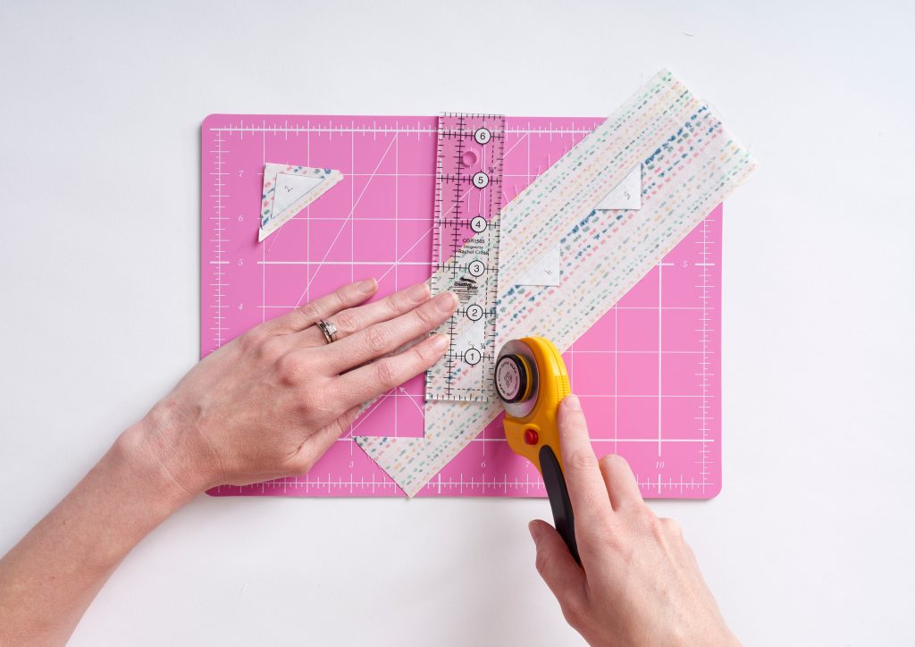 fabric, ruler and cutter on cutting board
