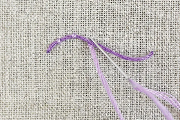 needle and thread demonstrating couching stitch