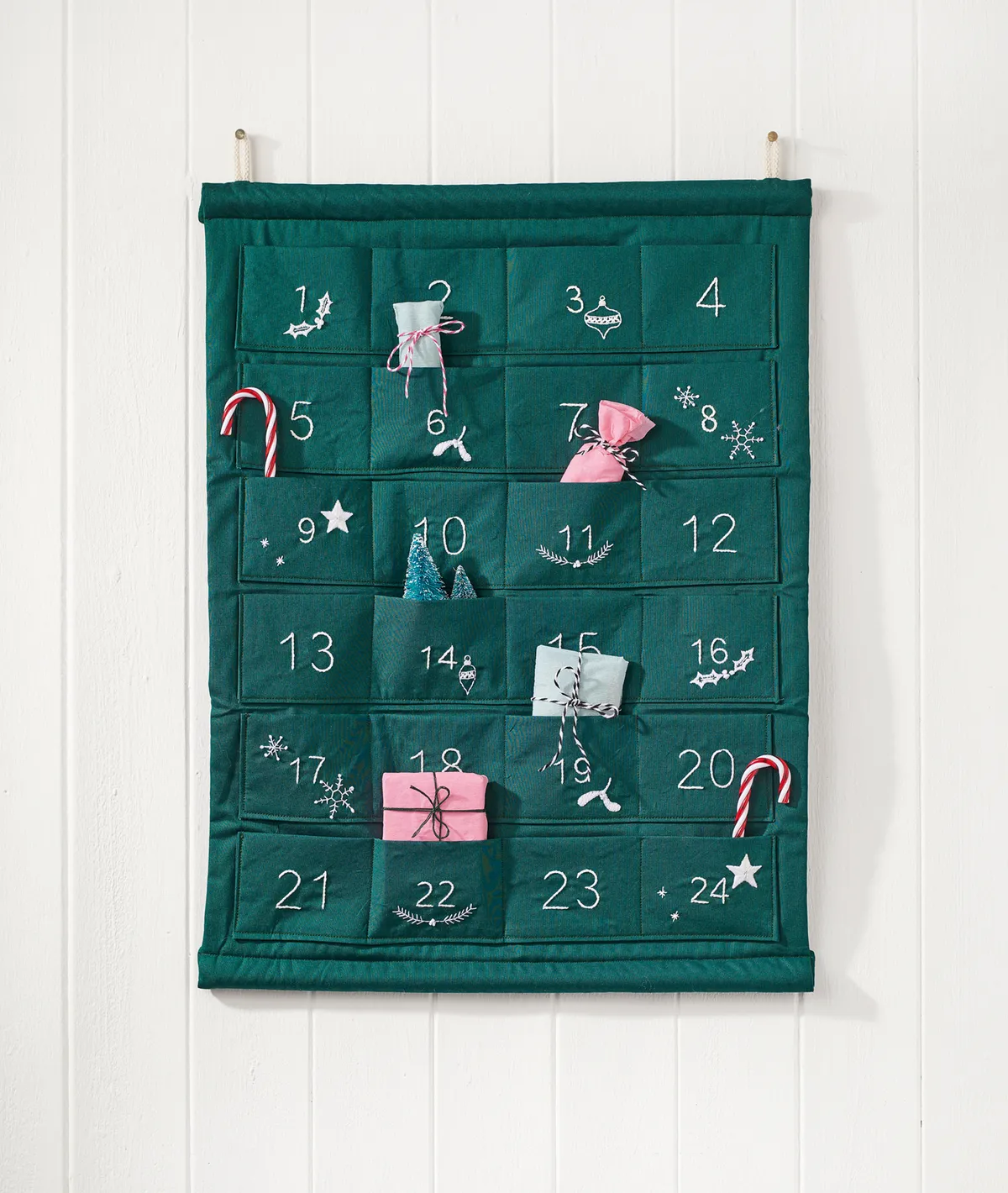 Handsewn green advent calendar with embroidered numbers and festive motifs
