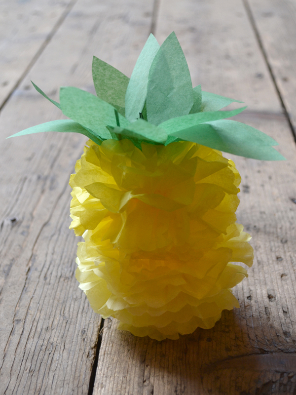 making paper pom poms into pineapples