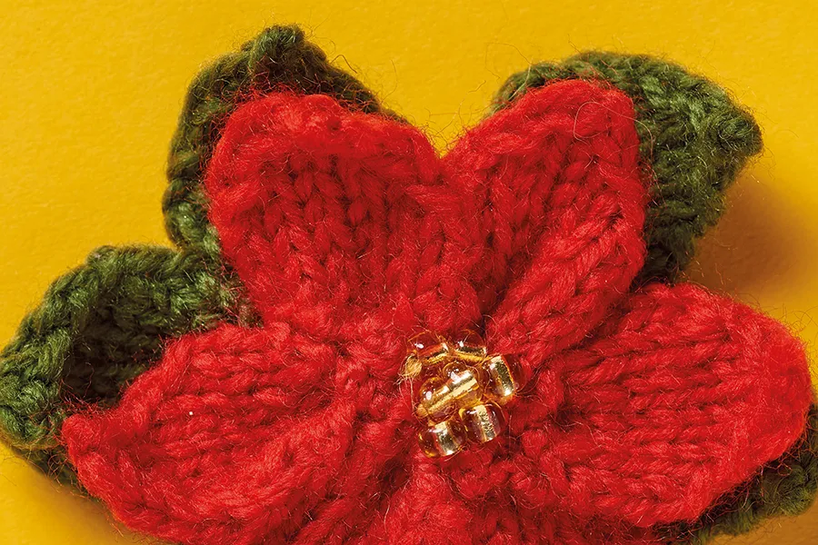 Knitted flower brooch poinsettia close up