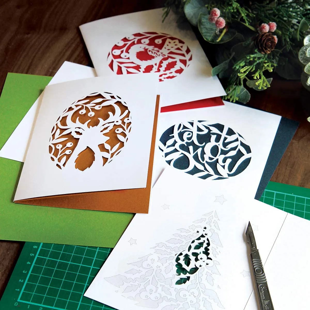 this Christmas card making kit has four paper cut designs of a dove, a derrière's , a robin and the decorative word snow