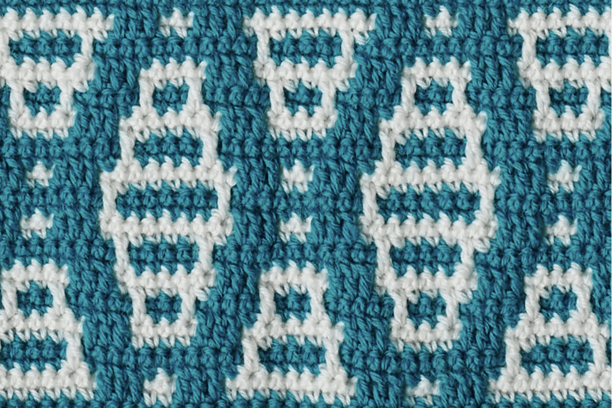 White on blue mosaic stitches in a piece of crochet
