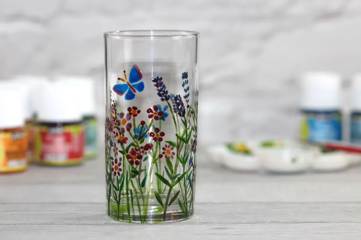 A half pint glass decorated with painted floral flowers