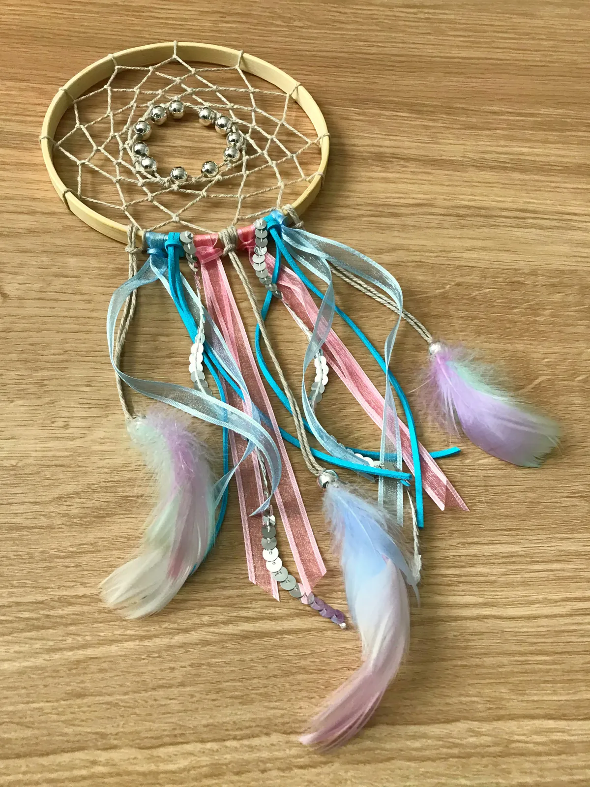 feather and ribbons hanging below a dreamcatcher