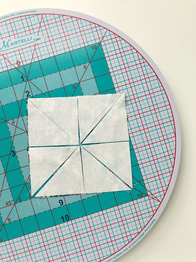white fabric cut into triangles on a quilting hoop